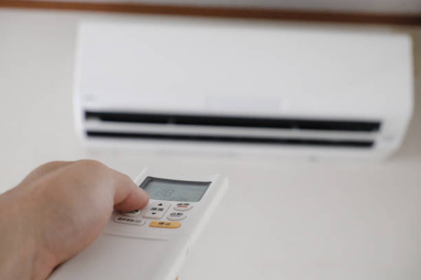 istock Image of operating the air conditioner with the remote control held in the hand 1321080263