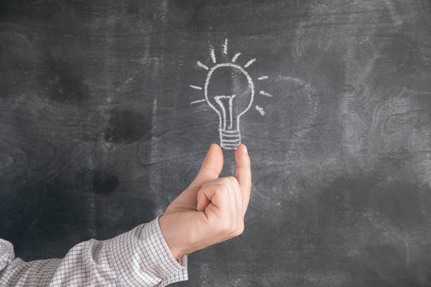 istock holding a lamp drawn in chalk on a blackboard 1321081911