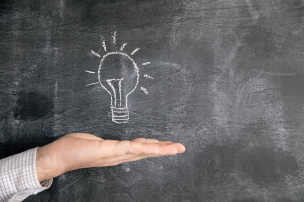 istock holding a lamp drawn in chalk on a blackboard 1321081922