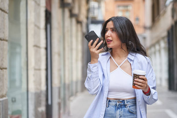 giovane donna che invia un messaggio audio con smartphone - arab style audio foto e immagini stock