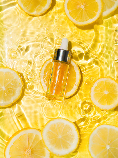Cosmetic bottle in water, lemon slices, yellow