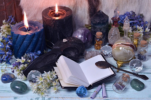 Still life with open diary book, crystals, flowers and burning candles.  Esoteric, gothic and occult background, Halloween mystic and wicca concept.