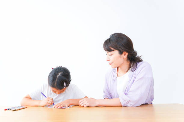 istock Girl studying with her mother at home 1321088068