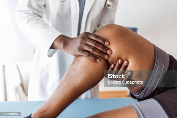 Doctor Consulting With Patient Knee Problems Physical Therapy Concept Stock Photo - Download Image Now