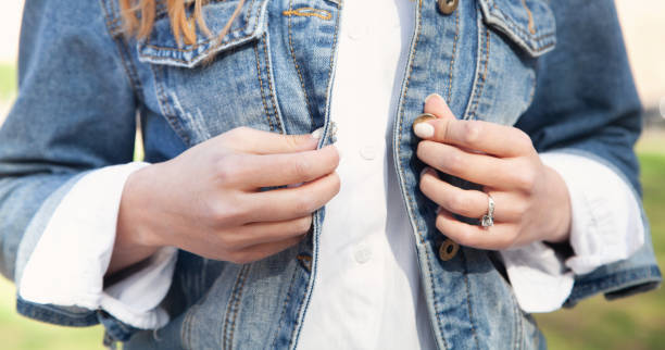 istock Woman fasten buttons a denim jacket. 1321092030