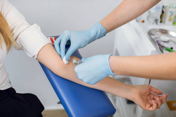 nahaufnahme aufgetauchtes bild von unkenntlich gemachtem arzt und patient. labortechniker krankenschwester durchbohrt die armvene des patienten mit nadel, um blut in die röhre zu sammeln. blutanalyse, spende, dna. - medizinische probe stock-fotos und bilder