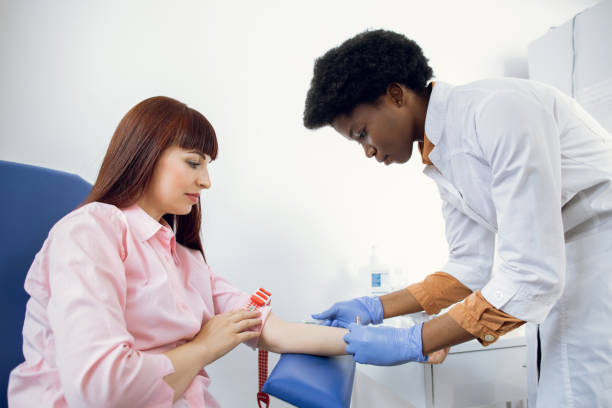 kan testi için hazırlık. beyaz tıbbi üniformalı güzel genç afrikalı kadın doktor hastanın damarından kan örneği almaya hazır. - kan bağışı stok fotoğraflar ve resimler