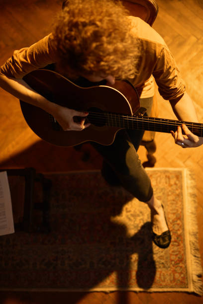 복고풍 빈티지 룸에서 어쿠스틱 기타를 연주하는 여성. - fingerstyle 뉴스 사진 이미지