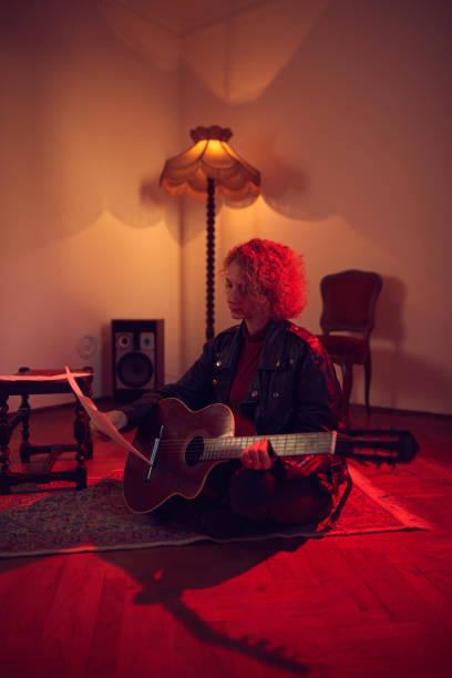 woman playing acoustic guitar in a retro vintage room. - fingerstyle imagens e fotografias de stock