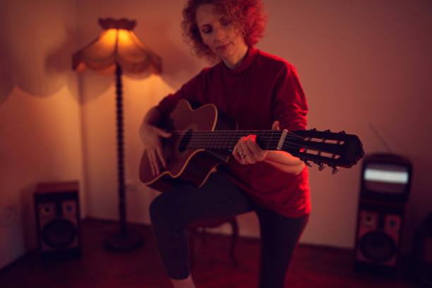 woman playing acoustic guitar in a retro vintage room. - fingerstyle imagens e fotografias de stock