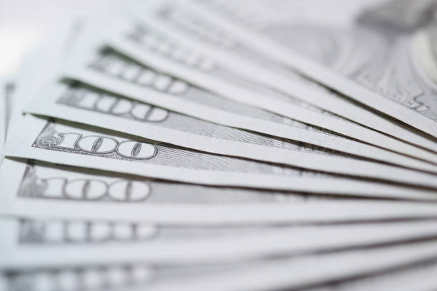 Hundred dollar bills fanned out on table