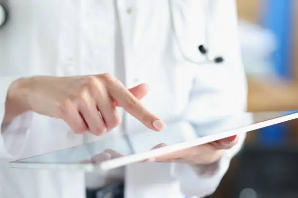 Medical officer doctor points his finger at tablet.Woman doctor workikng on digital tablet concept
