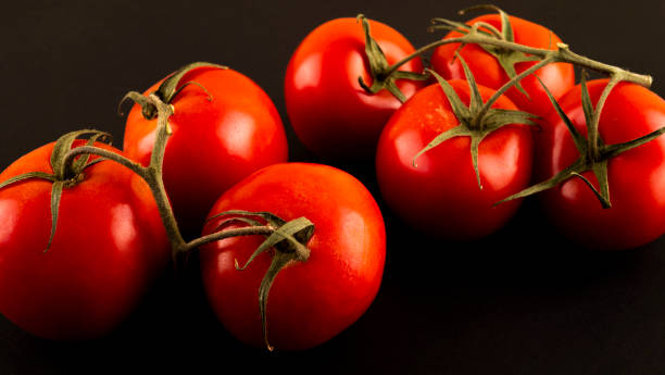 istock Fresh cherry tomatoes on a black background with spices. Top view with copy space. 1321097522