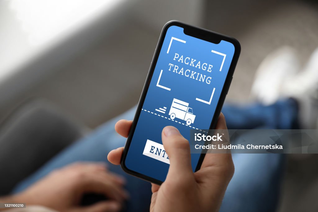 Man tracking parcel via smartphone indoors, closeup 2020 Stock Photo