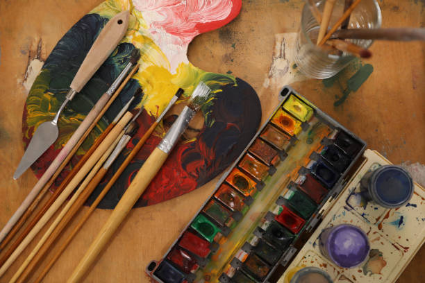 istock Spatula, brushes and paints on wooden table, flat lay 1321100713