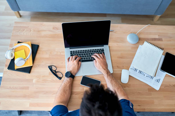 istock Overhead shot of man working on laptop working at home 1321101043