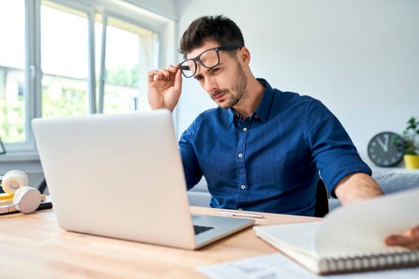 istock Young man looking with disbelief on laptop while working at home office 1321101658