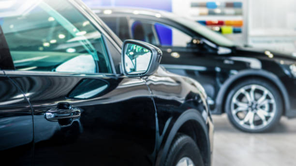 New cars at dealer showroom. New cars at dealer showroom. Blurred background. Fokus is on the handle from the left car empty dealership interior stock pictures, royalty-free photos & images