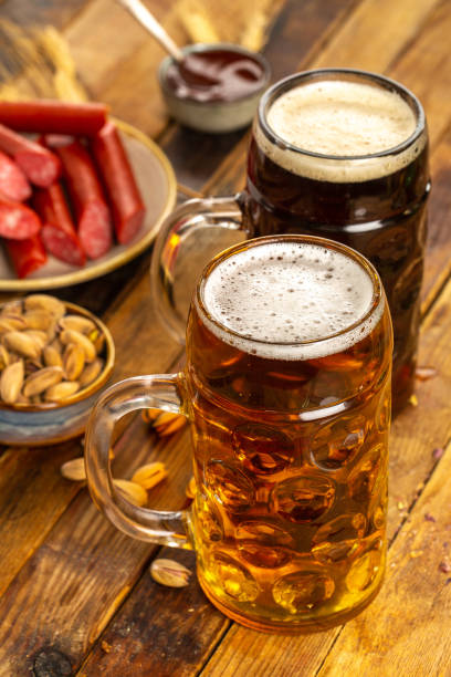 istock Dark and light beer in mugs close up 1321107044