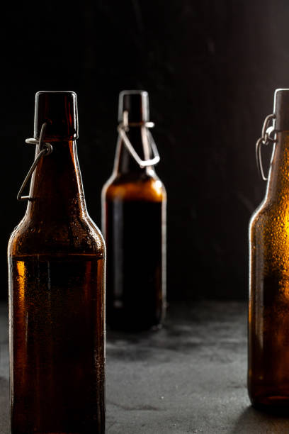 istock Dark crafted beer in glass and bottle on black background 1321107162