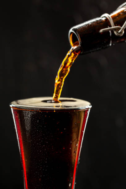 istock Dark crafted beer in glass and bottle on black background 1321107353