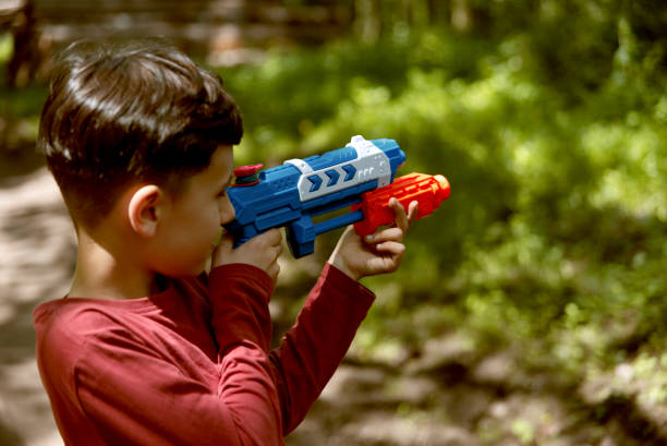 istock Portrait of young boy playing with water gun. 1321107585