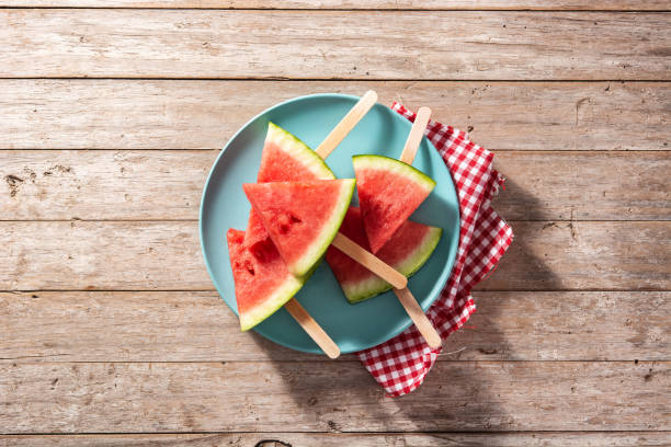 istock Watermelon slices popsicles on blue plate 1321108064