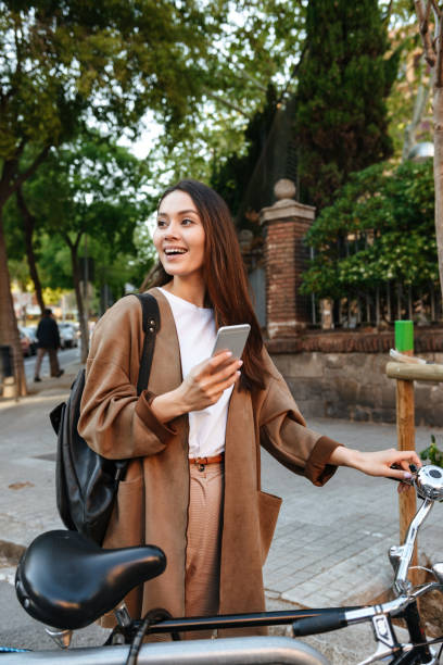 istock Amazing smiling beautiful woman on bicycle using mobile phone. 1321109160
