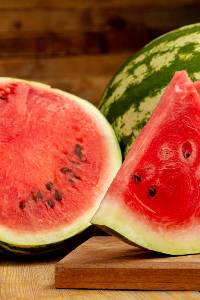 istock Watermelon and watermelon slice on wooden background 1321110117