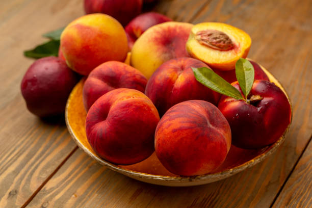 istock Peaches on wooden background in studio 1321110130