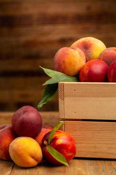 istock Peaches on wooden background in studio 1321110156