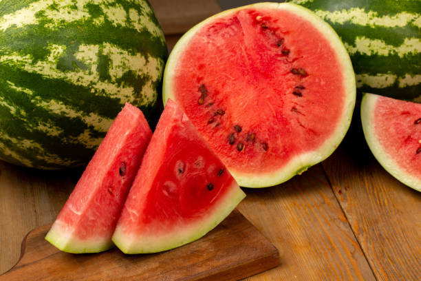 istock Watermelon and watermelon slice on wooden background 1321110158