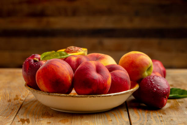 istock Peaches on wooden background in studio 1321110178
