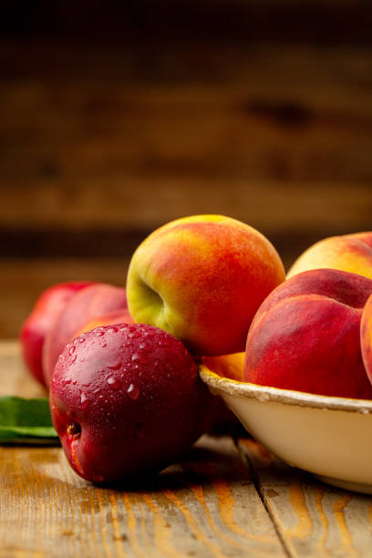 istock Peaches on wooden background in studio 1321110185