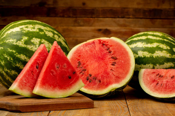 istock Watermelon and watermelon slice on wooden background 1321110205