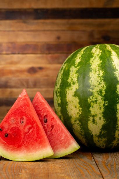 istock Watermelon and watermelon slice on wooden background 1321110311