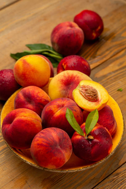 istock Peaches on wooden background in studio 1321110400