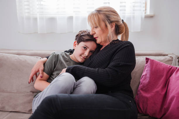 istock Boy cuddling with his mother at home 1321115006