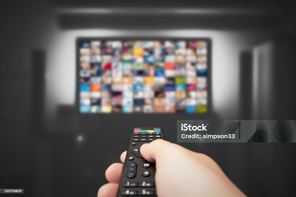 Video on demand, TV streaming, multimedia Video on demand, TV streaming, multimedia. Hand holding remote control Streaming Service Stock Photo