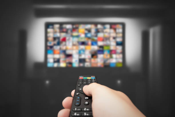 Video on demand, TV streaming, multimedia Video on demand, TV streaming, multimedia. Hand holding remote control television set stock pictures, royalty-free photos & images