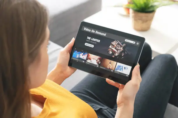 Video on demand, movie streaming, woman with tablet using video service