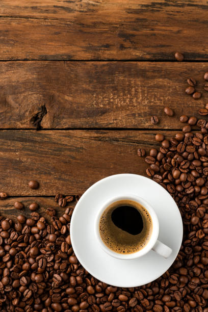 istock Coffee cup with beans on vintage wooden table with copyspace. Top view 1321116366