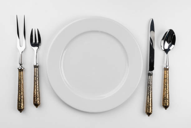 istock Empty plate with cutlery isolated on white background 1321117316
