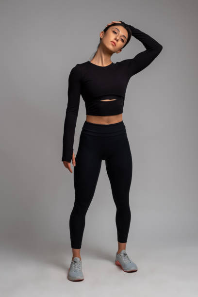 istock Sportswoman doing stretching exercises on grey background 1321121959