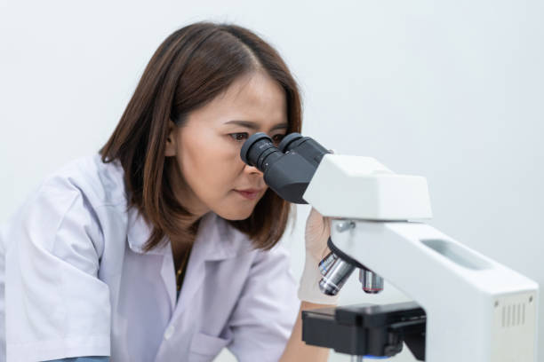 istock A young scientist woman in a laboratory coat looking through a microscope in a laboratory to do research and experiment. Scientist working in a laboratory 1321124966