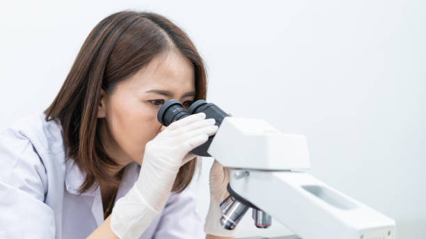 istock A young scientist woman in a laboratory coat looking through a microscope in a laboratory to do research and experiment. Scientist working in a laboratory 1321125019