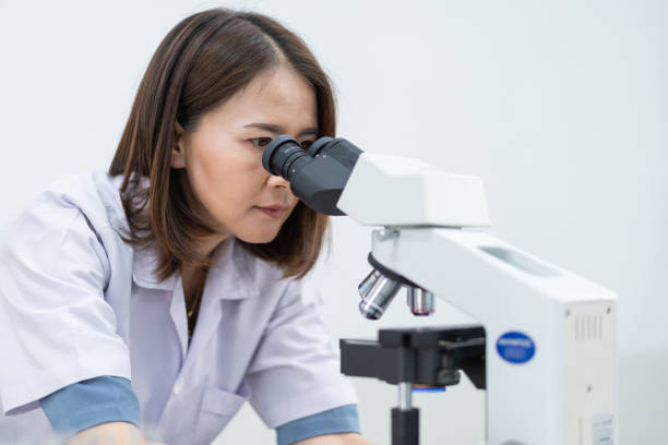 istock A young scientist woman in a laboratory coat looking through a microscope in a laboratory to do research and experiment. Scientist working in a laboratory 1321125068
