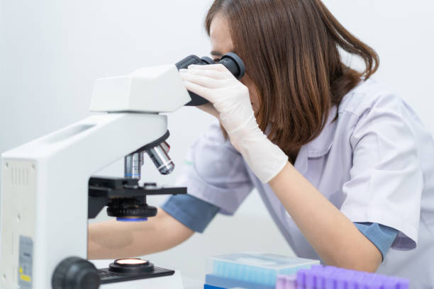 istock A young scientist woman in a laboratory coat looking through a microscope in a laboratory to do research and experiment. Scientist working in a laboratory 1321125244