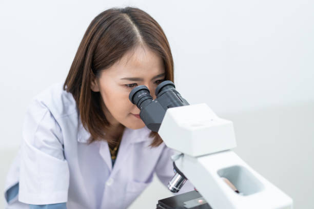 istock A young scientist woman in a laboratory coat looking through a microscope in a laboratory to do research and experiment. Scientist working in a laboratory 1321125606