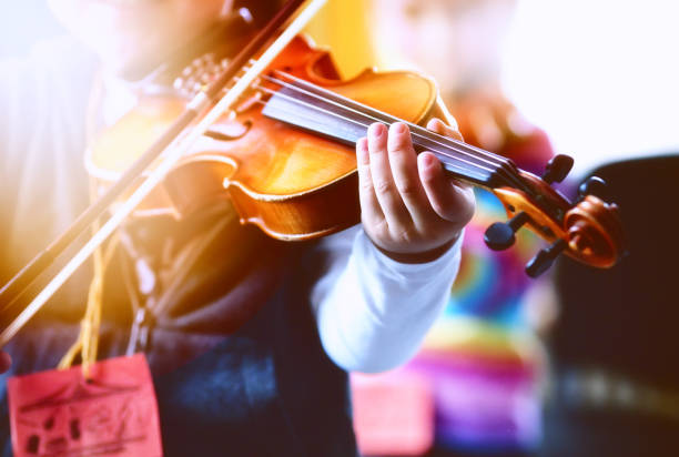 istock Child playing the violin in  room 1321125654